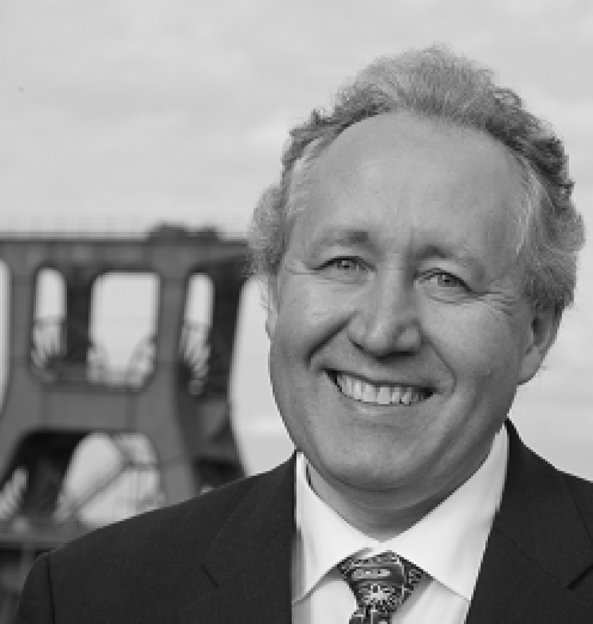 Das Schwarz-Weiß_Bild zeigt den fröhlichen Professor Doktor Josef Raab vor Förderturm der Zeche Zollverein.