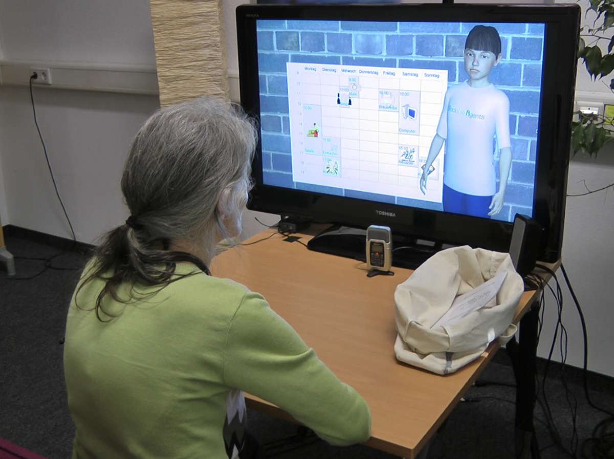 An older person looks at a screen showing a daily planer and a virtual agent.