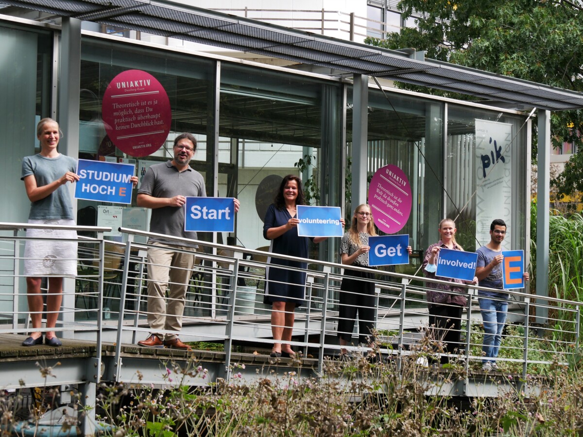Personen, die Schilder mit der Aufschrift "Studium hoch E, start volunteering, get involved" hochhalten