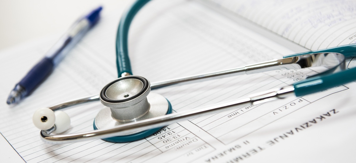 Ein Stetoskop, welches neben einem Stift liegt