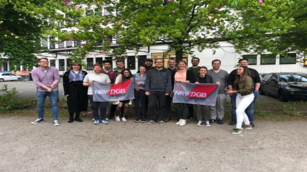 Menschen, die auf einem Gruppenfoto Flaggen des Deutschen Gewerkschaftsbundes hochhalten
