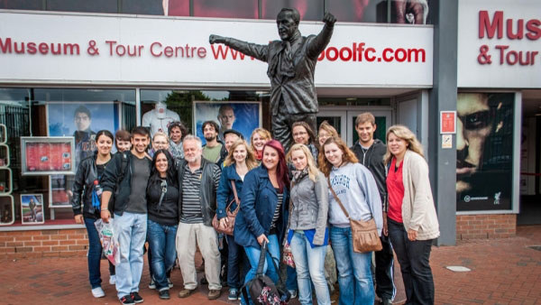 Bild von einer Gruppe von Studenten mit Herr Dean vor einer Bronzestatue in Liverpool..