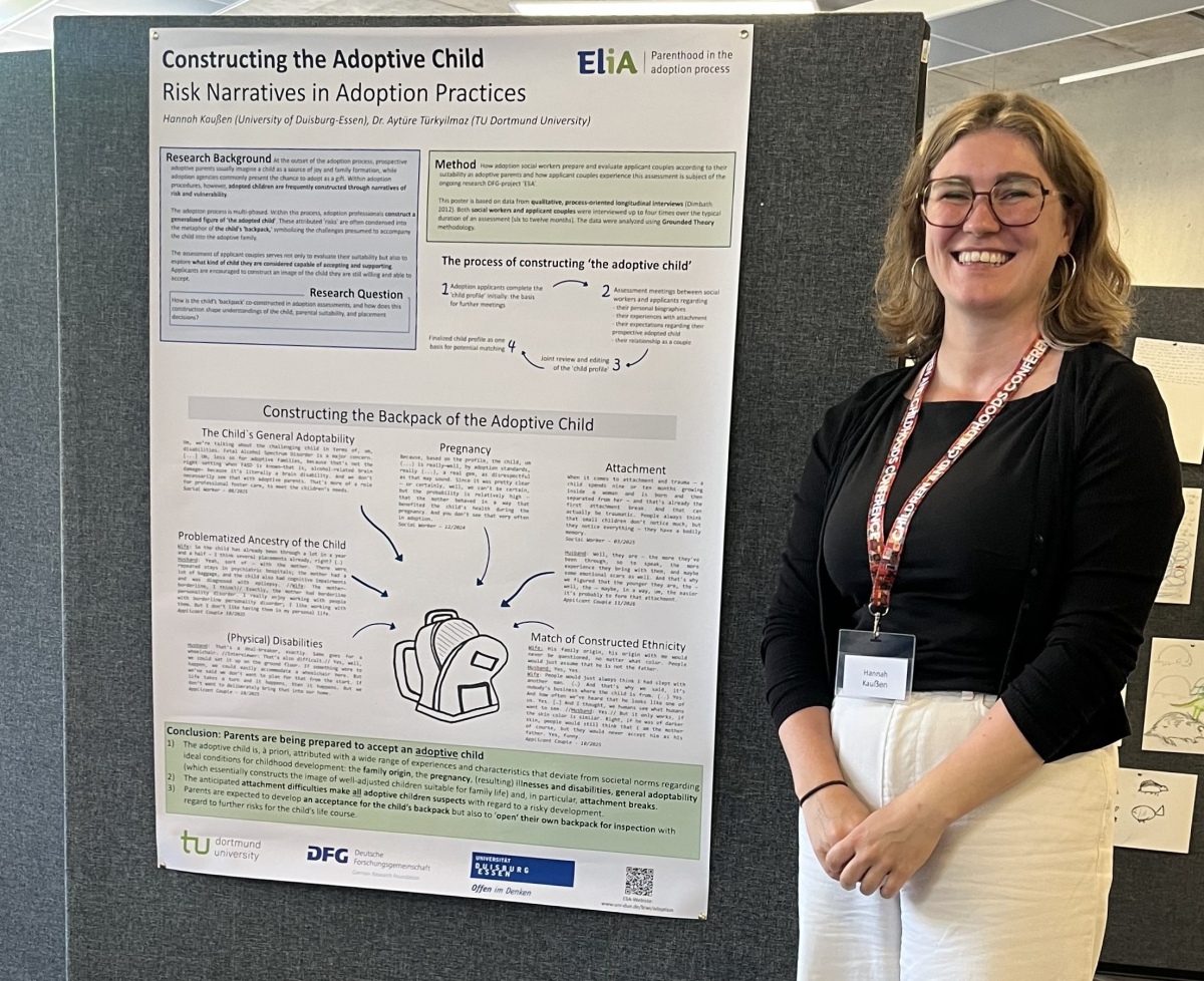 Picture of Hannah Kaußen smiling at the camera and standing in front of a presentation poster with the title "Constructing the Adoptive Child: Risk Narratives in Adoption Practices"
