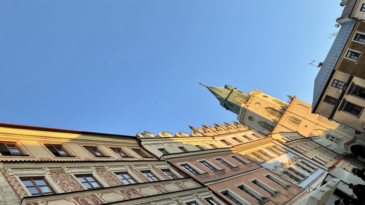 Photo of a row of buildings with a tower in the middle and a blue sky in the background