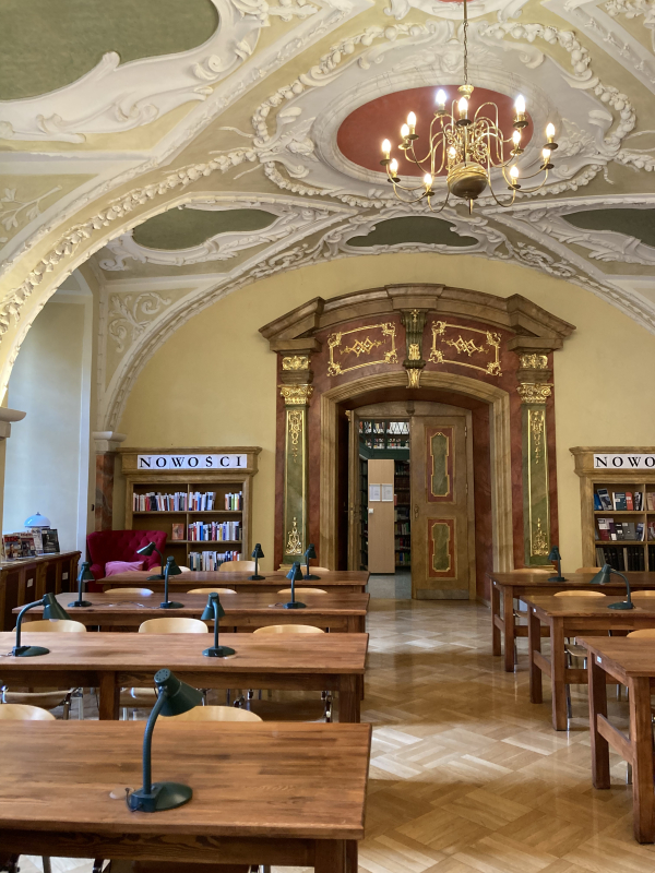 Photo of a library with wooden tables and colorful, ornate doors and ceiling