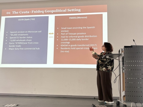 Picture of a Moroccan woman presenting on a stage. The slide's topic is 
