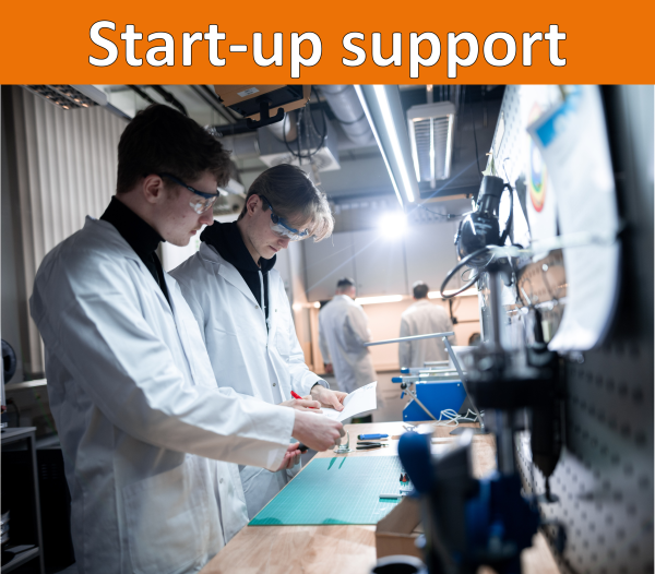 An orange bar with the heading “Founding.” Below it, a picture of two people wearing lab coats and safety goggles working at a workbench.