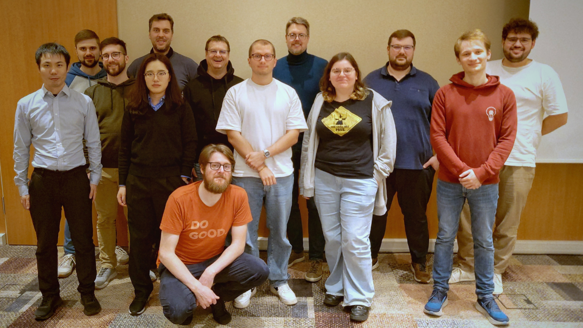 Das Team des Fachgebiets "Intelligente Eingebettete Systeme" und Prof. Dr. Herman Engelbrecht lachen in die Kamera