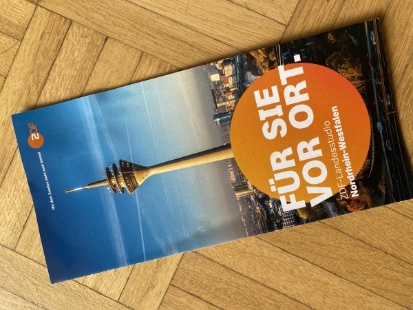 Das Foto zeigt den Flyer des ZDF-Landesstudios NRW. Sie sehen den Fernsehturm von Düsseldorf und die Aufschrift "Für Sie vor Ort."
