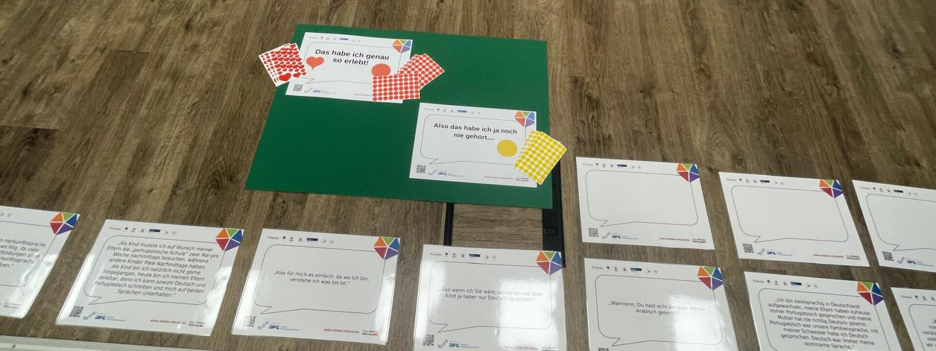 Detailansicht von Aussagen zu mehrsprachigem Aufwachsen mit Klebepunkten, um die eigenen ERfahrungen damit zu markieren
