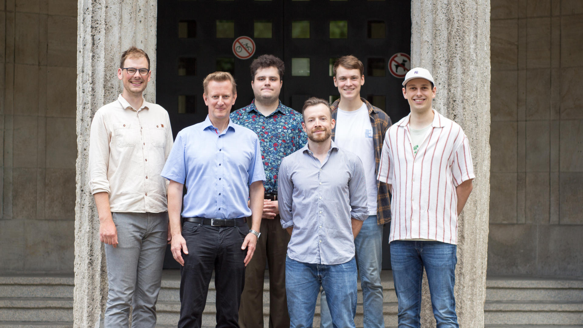 Professor, Mitarbeitende und wissenschaftliche sowie studentische Hilfskräfte des Lehrstuhls für Didaktik der Informatik stehen vor dem Gebäude S-A der Universität Duisburg-Essen