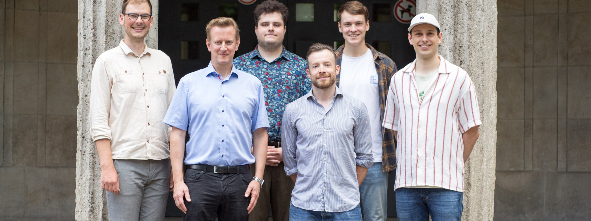 Professor, Mitarbeitende und wissenschaftliche sowie studentische Hilfskräfte des Lehrstuhls für Didaktik der Informatik stehen vor dem Gebäude S-A der Universität Duisburg-Essen