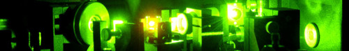 Picture of an optical laser setup illuminated in green laser light.