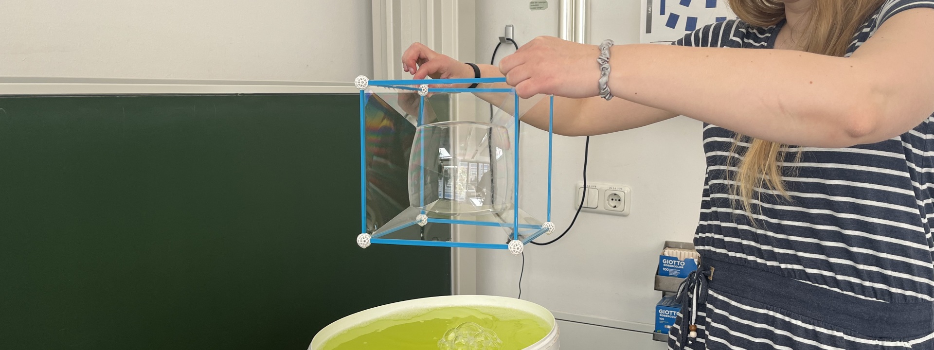 Das Bild zeigt wie man mit Seifenlauge Minimalflächen darstellen kann.