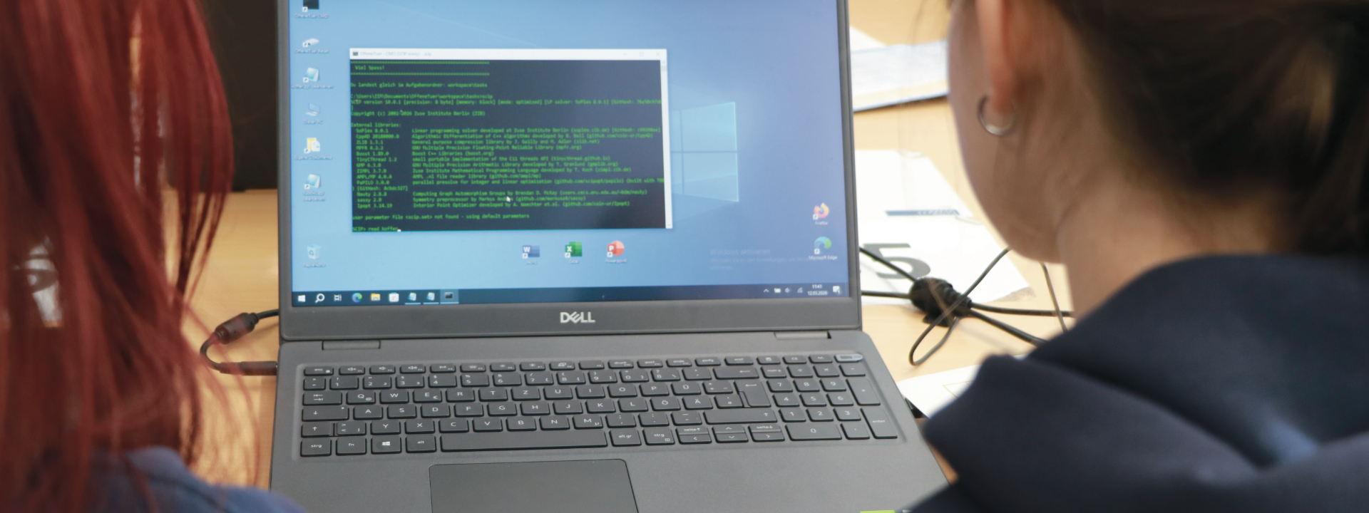 Zu sehen ist ein Laptop auf dessen Bildschirm gerade Programmcode geschrieben wird.