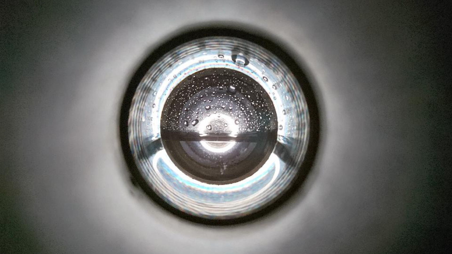 Tunnelartiger Blick auf ein Objekt, das einem kreisrunden Wassertropfen gleicht. Sehr abstrakt.