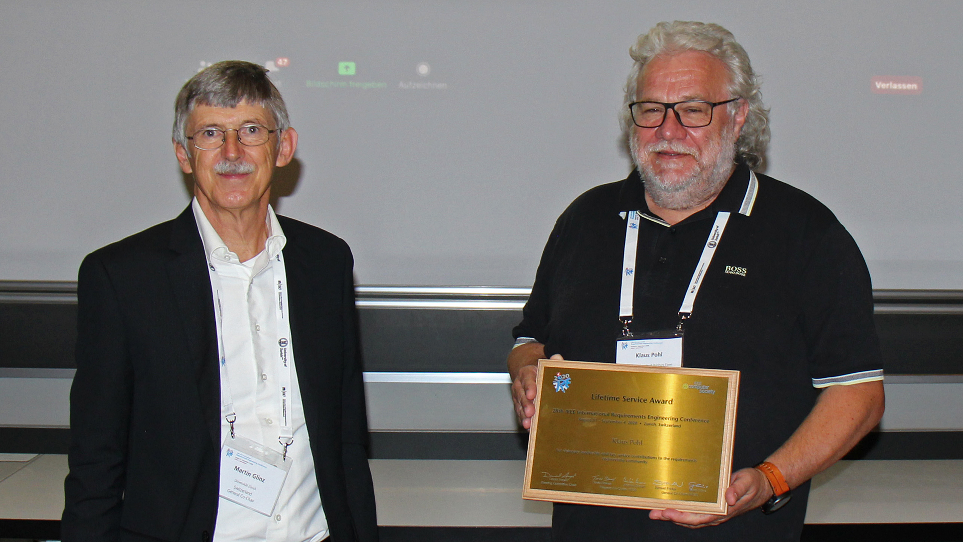 Prof. Martin Glinz (l.) übergibt Prof. Klaus Pohl (r.) in Zürich die Auszeichnung