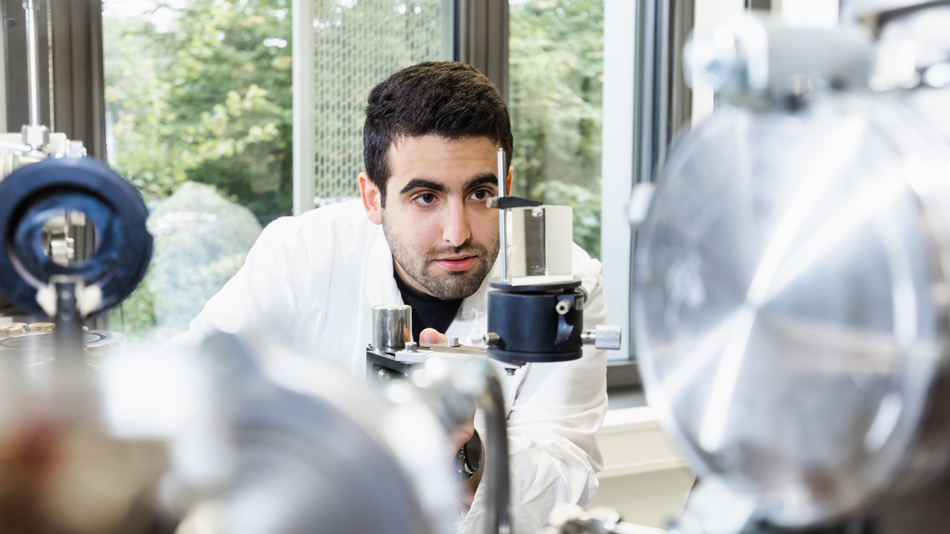 Abbas El Moussawi looks through an apparatus for laser diagnostics in his lab.