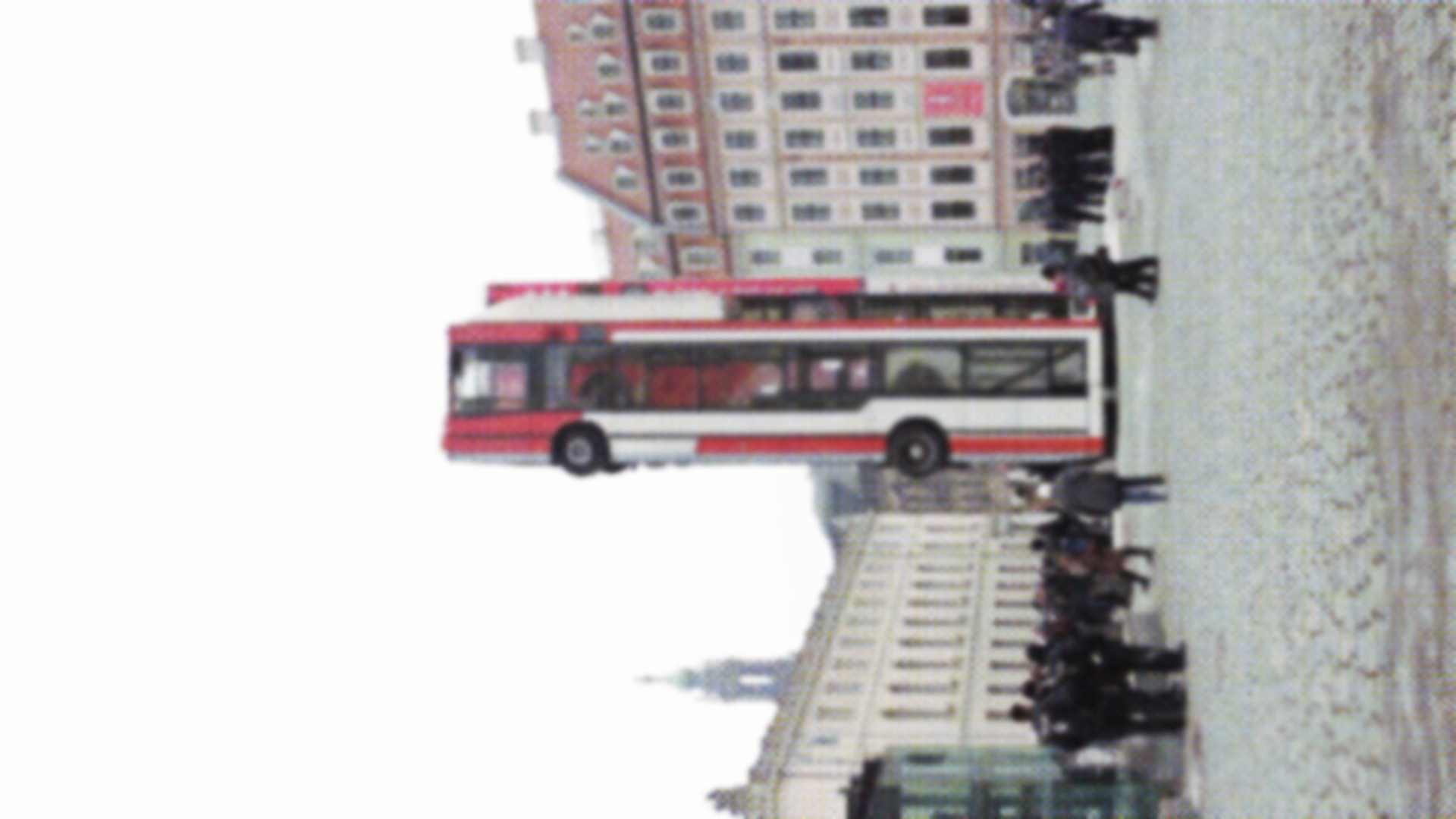 Foto eines auf dem Heck stehenden echten Linienbusses auf einem Marktplatz. Das Bild wiederum spielt auch mit der Perspektive und ist um 90° gedreht.