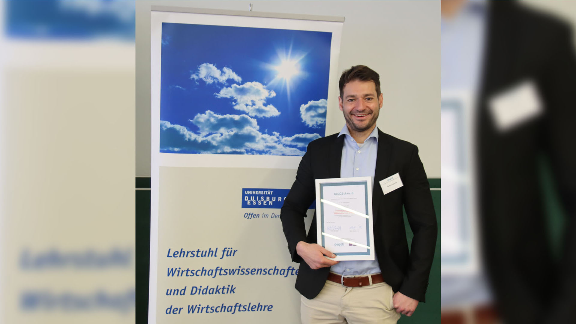 Dr. Steffen Spitzner, er hält die Urkunde in der rechten Hand