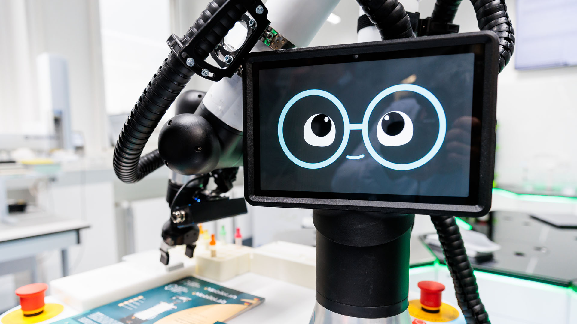 Ein Roboter mit einem Display, auf dem Augen zu sehen sind, die durch eine Brille schauen.