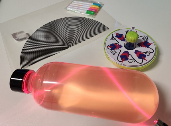 Aufbau des Schülerlabors, ein Laserstrahl in einer Flasche ist zu sehen und optische Experimente
