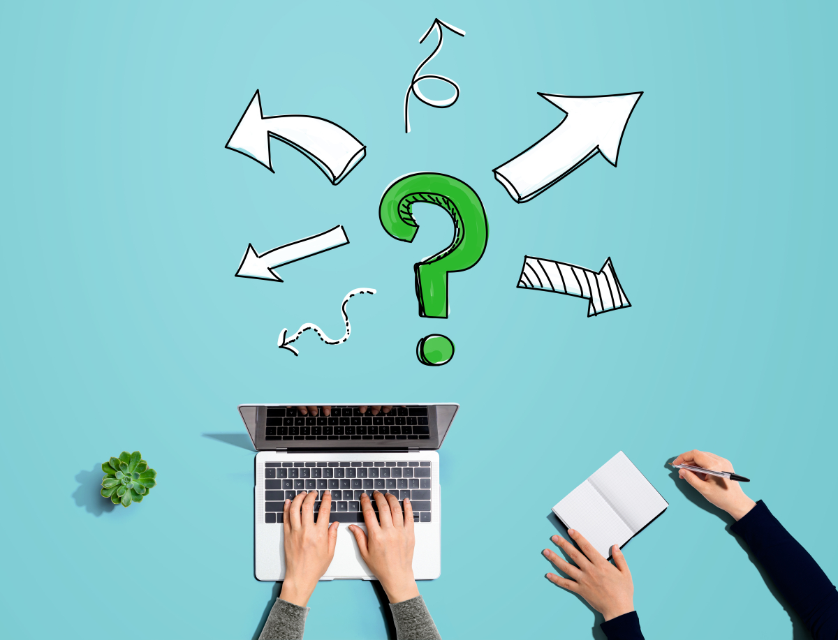 Ein Laptop, ein Notublock und ein Fragezeichen