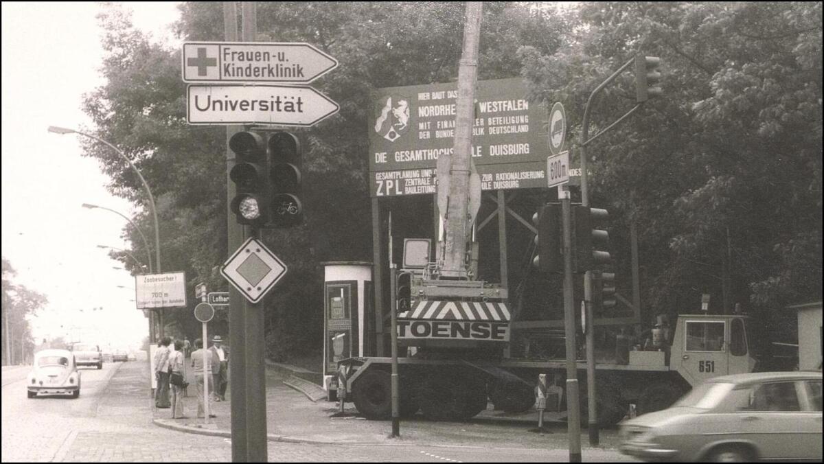 Bauschild der Gesamthochschule Duisburg und städtisches Straßenschild zur „Universität“ (15.06.1976)