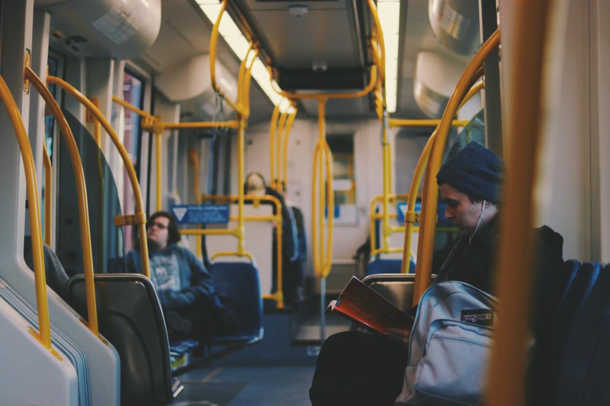 Innenansicht eines Busses, in dem mehrere Menschen sitzen