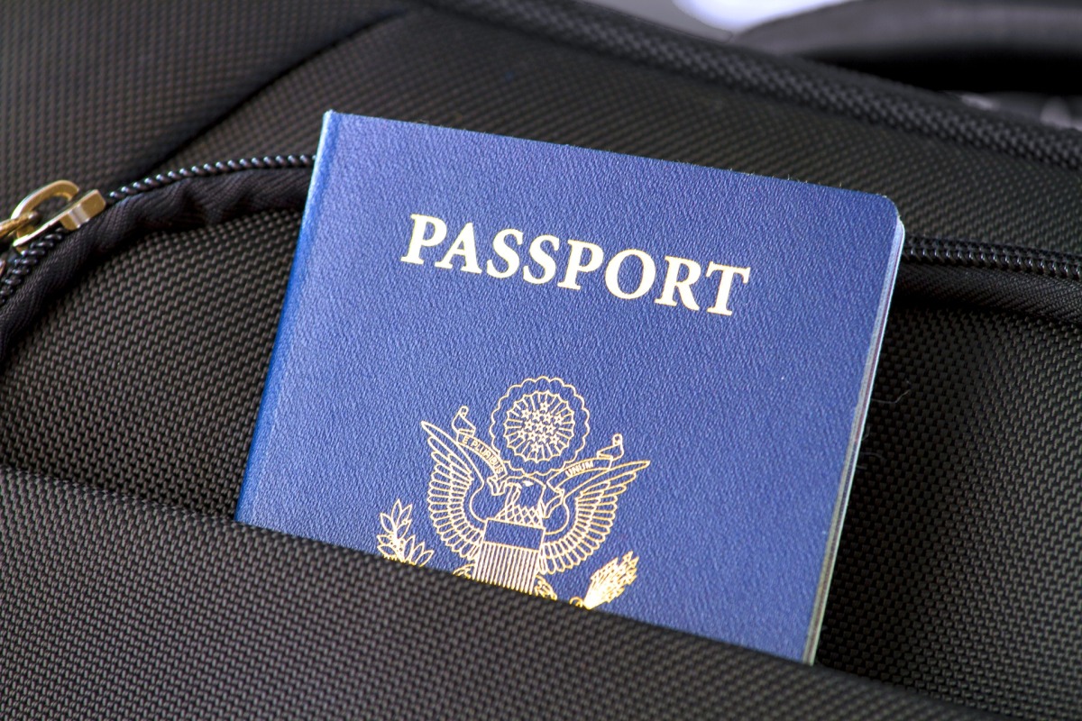 (Symbolbild) Ein blauer Pass, der aus der Hosentasche eines Mannes herausschaut